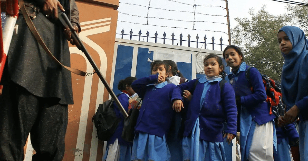 School going Students, besides a school guard holding a rifle