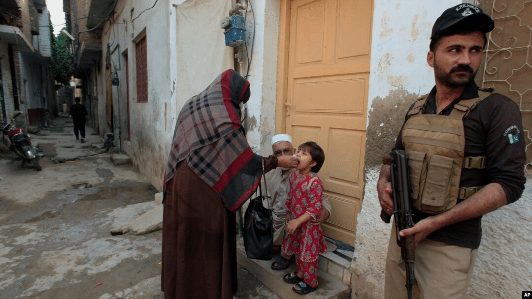 The Anti-Polio Jihad: Exposing FAK’s Deliberate Campaign Against Public Health Initiatives Health care worker administering vaccination in the presence of police official